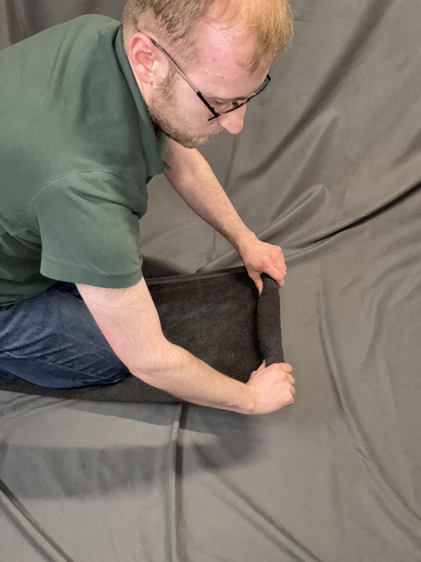 A towel being rolled with outward tension.