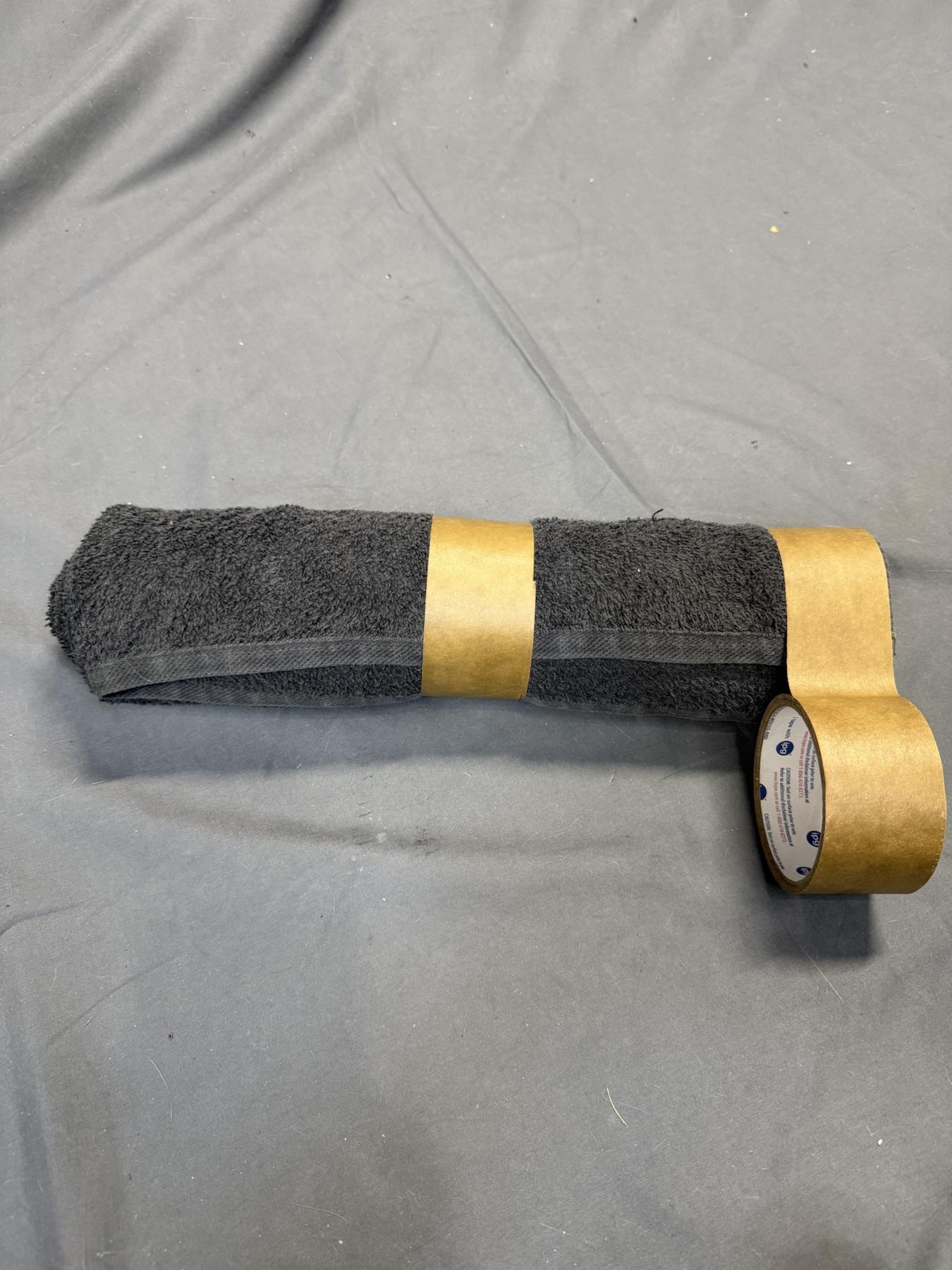 Tape being added to the right side of the towel roll.