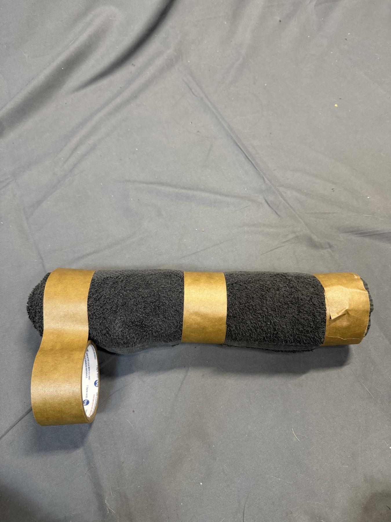 Tape being added to the left side of the towel roll.