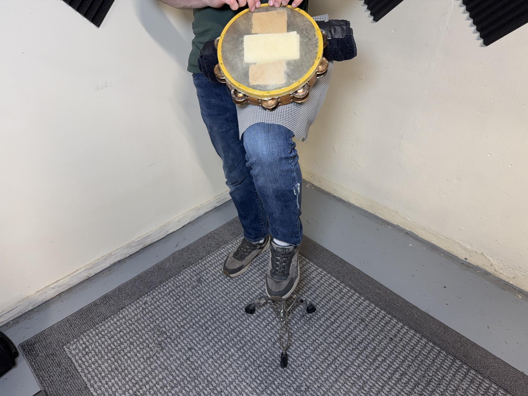 TAM-BURRITO and tambourine resting on a raised leg.