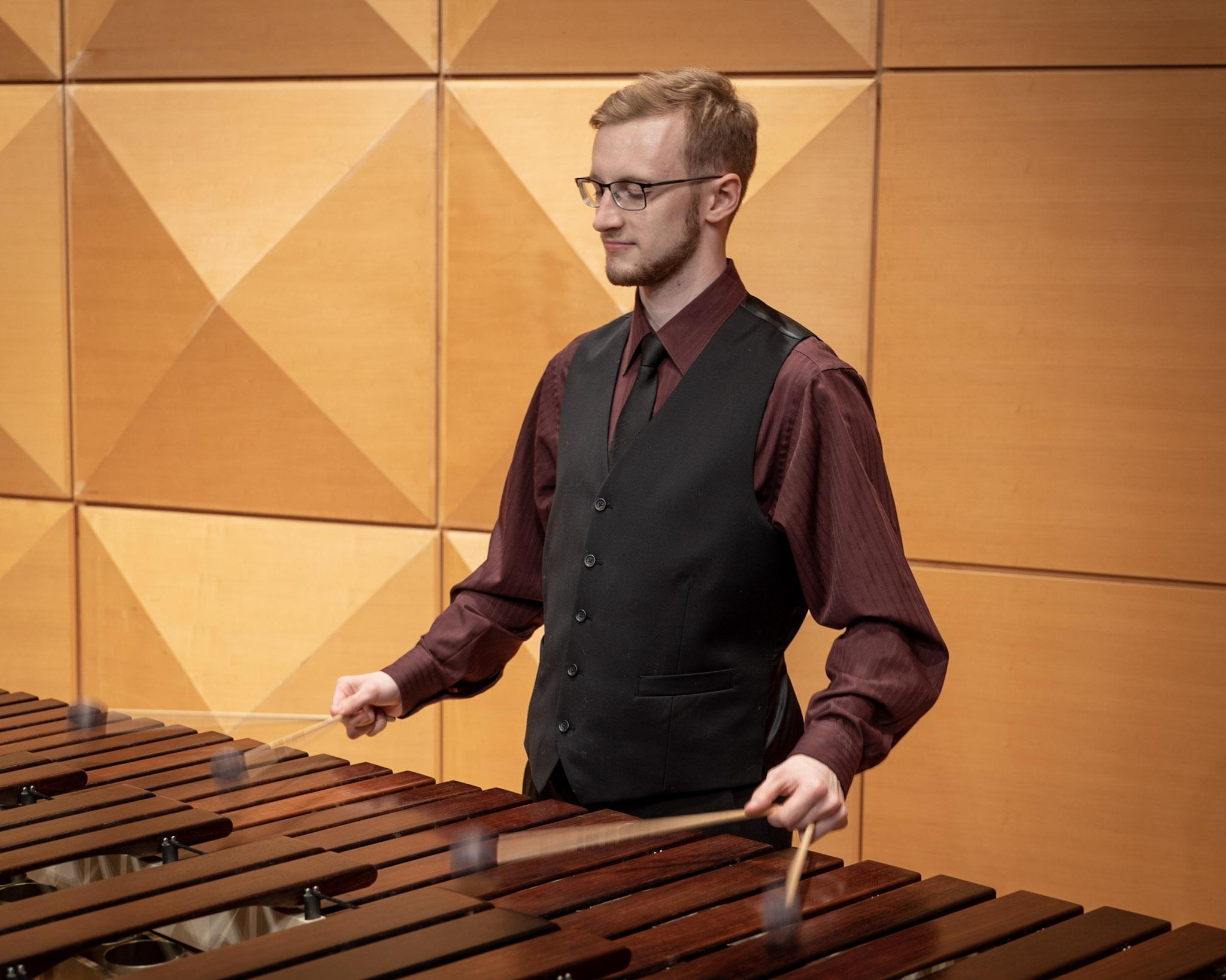 Spencer Perilloux performing marimba in a recital hall.